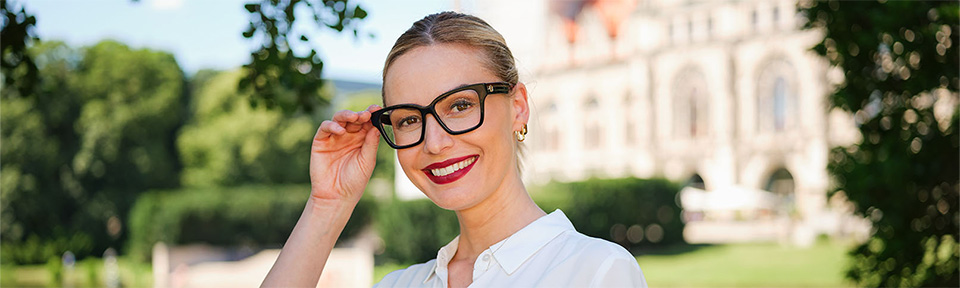 Eine Frau trägt eine Kunststoffbrille vor dem alten Rathaus in Hannover.