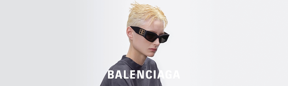 Eine Frau trägt eine Balenciaga Sonnenbrille, während Sie von vielen Mikrofonen umgeben ist.