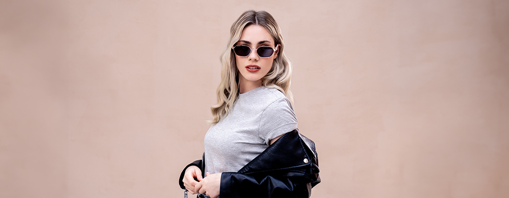 Eine blonde Fraut trägt eine goldene Gucci Sonnenbrille.