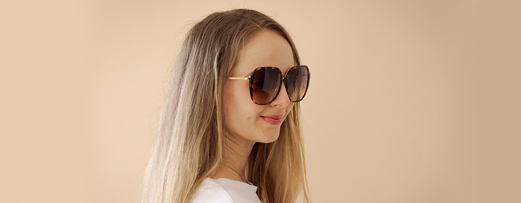 Eine Frau trägt eine Linda Farrow Sonnenbrille im Leopardenmuster.