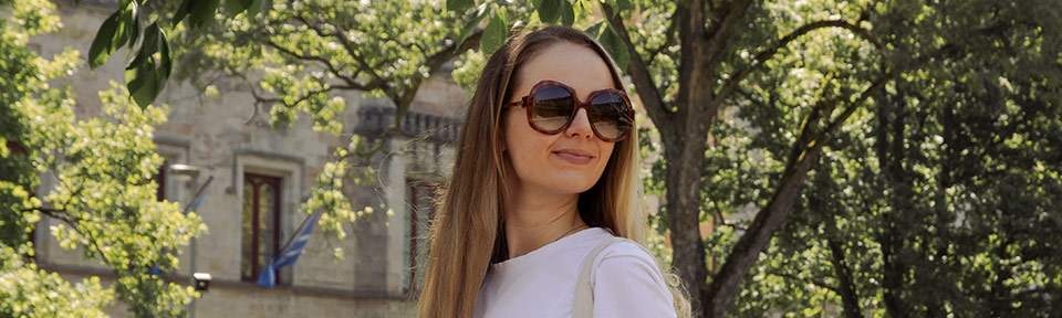 Eine Fra trägt im grünen eine Oversized Sonnenbrille.