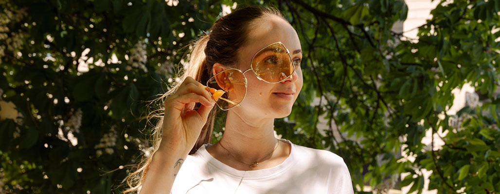 Eine Frau hält eine Gucci Sonnenbrille vor Ihr Gesicht.