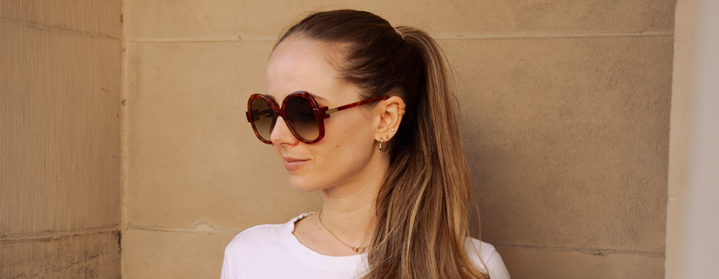 Eine Frau trägt eine Linda Farrow Sonnenbrille. 