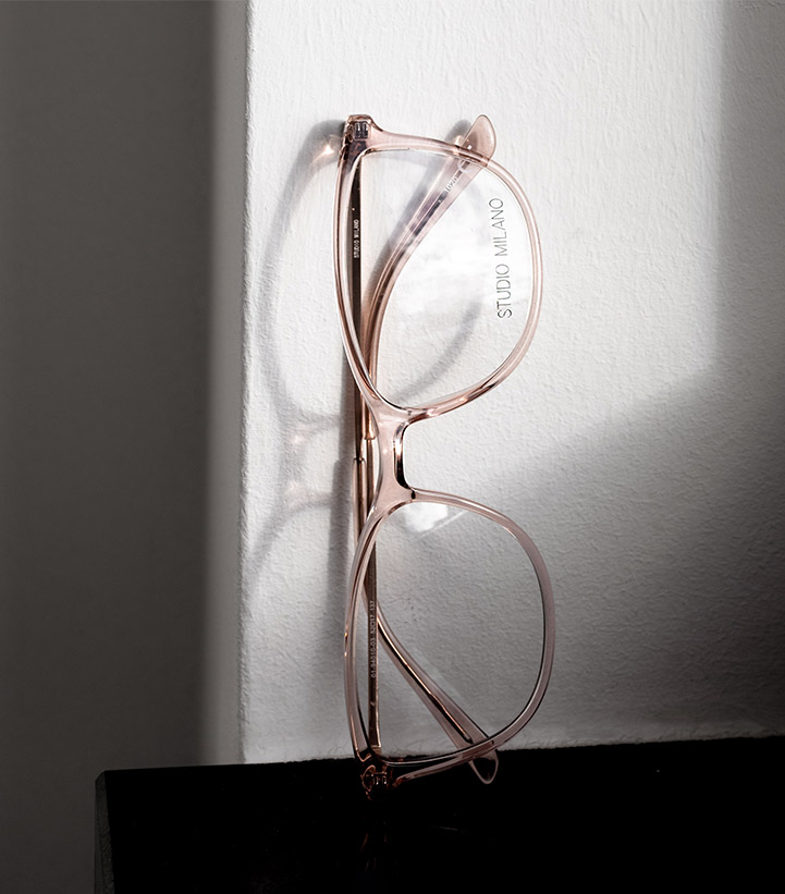 Nahaufnahme einer Brille von Studio Milano, die an einer Wand lehnt.